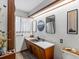 Mid-century modern bathroom with wood cabinets and unique wall art at 1750 Vance St, Lakewood, CO 80214