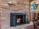 Stone fireplace with a black metal screen and a glowing fire at 1750 Vance St, Lakewood, CO 80214