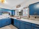 Updated kitchen featuring blue cabinetry, copper farmhouse sink, and quartz countertops at 1750 Vance St, Lakewood, CO 80214