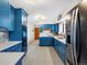 Modern kitchen with blue cabinets, copper sink, and stainless steel appliances at 1750 Vance St, Lakewood, CO 80214