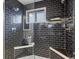 Modern shower with dark tile, glass enclosure, and built-in seat at 1750 Vance St, Lakewood, CO 80214