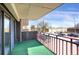 Cozy balcony features green carpet, red railing, and views of the street and surrounding neighborhood at 3675 S Cherokee St # 110, Englewood, CO 80110