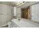 Bathroom with white vanity, mirror, and shower with earth-tone tiles at 3675 S Cherokee St # 110, Englewood, CO 80110