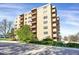Side view of the condo building showcasing balconies, landscaping, and an access road at 3675 S Cherokee St # 110, Englewood, CO 80110