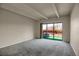 Living room with gray carpet and sliding glass door to balcony with green turf at 3675 S Cherokee St # 110, Englewood, CO 80110