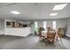 Neutral colored community sitting area with four chairs and a small table, three windows and carpeted floors at 3675 S Cherokee St # 110, Englewood, CO 80110