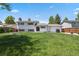 Back exterior view of house featuring a large grassy lawn, trees, and neutral colored siding at 2554 S Laredo Ct, Aurora, CO 80013