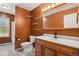 Bathroom with wooden vanity, decorative shelves, and a window view of shower at 2554 S Laredo Ct, Aurora, CO 80013