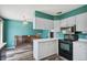 Kitchen with white cabinets and black appliances overlooking an open concept living area at 2554 S Laredo Ct, Aurora, CO 80013