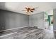 Living room with wood-look floors, gray walls, ceiling fan and open view to the kitchen at 2554 S Laredo Ct, Aurora, CO 80013