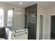 Modern bathroom with glass shower, neutral tile, and window at 1970 S Logan St, Denver, CO 80210