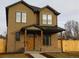 Inviting two-story home with a brick and stucco facade, featuring a covered porch and well-maintained landscaping at 1970 S Logan St, Denver, CO 80210