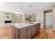 Kitchen island with a sink, marble countertops, and a view of the living room fireplace at 1970 S Logan St, Denver, CO 80210