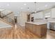 Open concept kitchen with a central island, hardwood floors, and access to a staircase at 1970 S Logan St, Denver, CO 80210