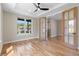 Bright, airy living room with hardwood floors, large windows, modern ceiling fan and glass panel French doors at 1970 S Logan St, Denver, CO 80210