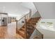 Well-lit staircase featuring wood steps with iron railings, offering a glimpse into the open-concept living area at 1970 S Logan St, Denver, CO 80210
