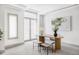 Bright home office with an oval wooden desk and two ottomans at 105 Fillmore St # 204, Denver, CO 80206