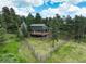 Secluded two-story home with a sprawling yard and fencing, surrounded by trees at 31258 Niakwa Rd, Evergreen, CO 80439
