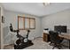 Bedroom showcases exercise equipment, neutral decor, and wood-trimmed windows at 31258 Niakwa Rd, Evergreen, CO 80439