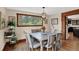 Bright dining room offers backyard views, an elegant chandelier, and seating for six at 31258 Niakwa Rd, Evergreen, CO 80439