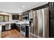 Modern kitchen with stainless steel appliances, dark cabinetry, and elegant tile backsplash at 31258 Niakwa Rd, Evergreen, CO 80439