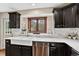 Charming kitchen features a farmhouse sink, sleek countertops, dark cabinetry, and a scenic window view at 31258 Niakwa Rd, Evergreen, CO 80439