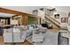 Comfortable living room features a plush gray sectional, hardwood floors, and staircase to upper level at 31258 Niakwa Rd, Evergreen, CO 80439