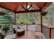 Cozy covered porch with inviting chairs, a hanging swing, and verdant scenery at 31258 Niakwa Rd, Evergreen, CO 80439