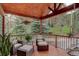 Relaxing covered porch with stylish furniture, hanging flower baskets, and peaceful outdoor views at 31258 Niakwa Rd, Evergreen, CO 80439
