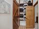 Open walk-in closet with wood shelves, organized baskets and a rustic, sliding barn door at 31258 Niakwa Rd, Evergreen, CO 80439