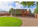 Backyard featuring a deck, fenced yard and mature trees at 13849 W 66Th Dr, Arvada, CO 80004