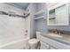 A bathroom featuring a white tiled shower, a granite vanity top and modern fixtures at 13849 W 66Th Dr, Arvada, CO 80004