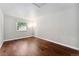 A bright, empty bedroom features hardwood floors and a large window at 13849 W 66Th Dr, Arvada, CO 80004