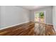 A bright, empty bedroom features hardwood floors and a sliding door leading to the deck at 13849 W 66Th Dr, Arvada, CO 80004