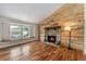 Cozy living room featuring a stone fireplace and large window with natural light at 13849 W 66Th Dr, Arvada, CO 80004