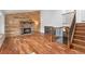 Open-concept living space with a stone fireplace and hardwood floors at 13849 W 66Th Dr, Arvada, CO 80004