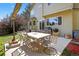 A patio with table and chairs sits off the back of this tan home, perfect for outdoor enjoyment at 10343 Stoneflower Dr, Parker, CO 80134