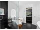 Bright bathroom features a soaking tub with an arched window and modern black and white accents at 10343 Stoneflower Dr, Parker, CO 80134