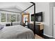 Modern bedroom features a unique four-poster bed, large window view, and sleek, dark furnishings at 10343 Stoneflower Dr, Parker, CO 80134