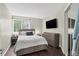 This bedroom features a large window, TV, neutral walls, and gray furniture on dark hardwood floors at 10343 Stoneflower Dr, Parker, CO 80134
