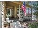 Inviting front porch with neutral paint and classic wood railing, and an American flag waving in the breeze at 10343 Stoneflower Dr, Parker, CO 80134