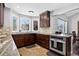 Gourmet kitchen with dark wood cabinets, stone countertops, stainless steel appliances, and lots of natural light at 10343 Stoneflower Dr, Parker, CO 80134