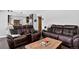 Warm living room with leather sofas, wood accents, and view to an eat-in kitchen at 10343 Stoneflower Dr, Parker, CO 80134