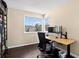Office space filled with natural light features dark floors, a modern desk, and an ergonomic chair at 10343 Stoneflower Dr, Parker, CO 80134