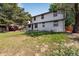 Spacious backyard with a lawn and mature trees and showing the home's rear facade at 10851 E Iliff Pl, Aurora, CO 80014