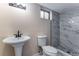 Modern bathroom with pedestal sink and marble tiled shower at 10851 E Iliff Pl, Aurora, CO 80014
