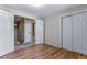 View of bedroom features hardwood floors, closet, and access to stairs and hall at 10851 E Iliff Pl, Aurora, CO 80014