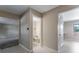 Hallway featuring a view of a half bathroom with a toilet and a doorway to a room with gray carpet and neutral colored walls at 10851 E Iliff Pl, Aurora, CO 80014
