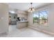 Open-concept kitchen with a breakfast bar, white countertops, and natural light from a large window at 10851 E Iliff Pl, Aurora, CO 80014