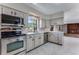Well-lit kitchen with white cabinets, stainless steel appliances, and marble floors at 10851 E Iliff Pl, Aurora, CO 80014